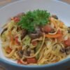 Korean-style kimchi-flavored stir-fried pasta topped with vegetables