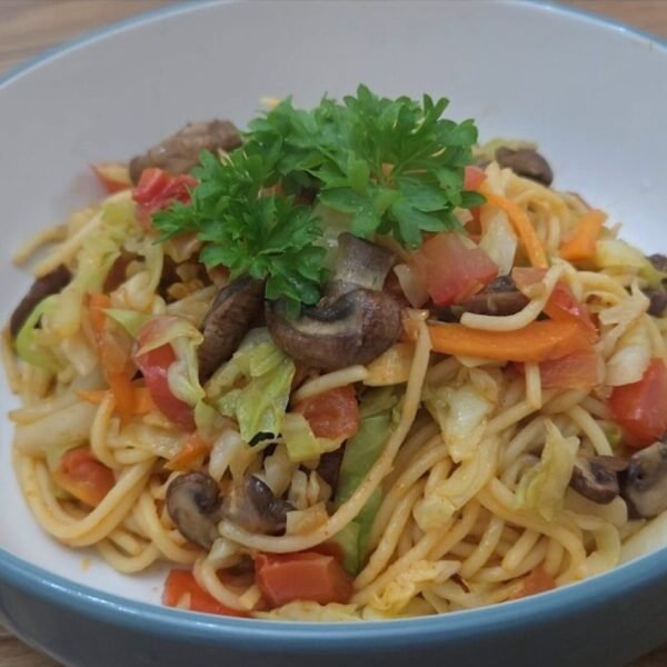 Korean-style kimchi-flavored stir-fried pasta topped with vegetables