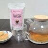 Glass teapot with freshly brewed CHIU STYLE Assam Black Tea, stand-up pouch of Assam Black Tea, and pineapple pastry on the side