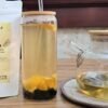 CHIU STYLE Lemon Coconut Green Tea stand-up pouch, brewed lemon coconut green tea with pearls and orange slices, and a teapot filled with the same tea