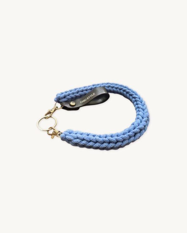 Side profile view of the CHIU STYLE Braided Keychain in Cornflower Blue resting on a textured surface.