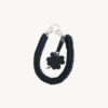 Front view of the CHIU STYLE clover vegan leather braided keychain in classic black, featuring a matching die-cut four-leaf clover tag and polished silver hardware