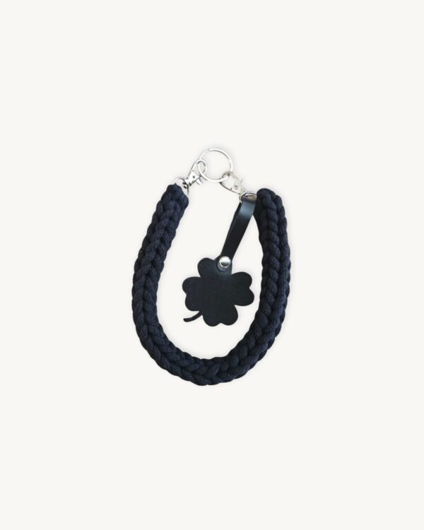 Front view of the CHIU STYLE clover vegan leather braided keychain in classic black, featuring a matching die-cut four-leaf clover tag and polished silver hardware