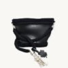Black clover vegan leather braided keychain looped around a tote bag handle, demonstrating easy key access inside a handbag