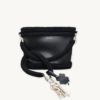 Black clover vegan leather braided keychain looped around a tote bag handle, demonstrating easy key access inside a handbag