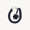Front view of the CHIU STYLE clover vegan leather braided keychain in black with silver thread, featuring a matching die-cut four-leaf clover tag and polished silver hardware