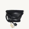 Black with silver thread clover vegan leather braided keychain looped around a tote bag handle, demonstrating easy key access inside a handbag