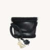 Black with silver thread clover vegan leather braided keychain looped around a tote bag handle, demonstrating easy key access inside a handbag