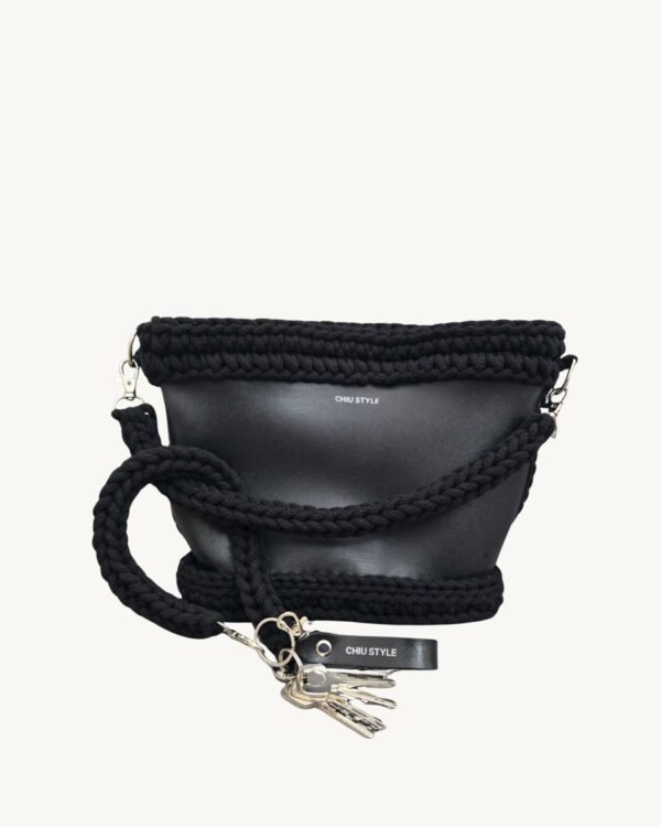 Black vegan leather braided keychain looped around a tote bag handle, demonstrating easy key access inside a handbag