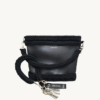 Black vegan leather braided keychain looped around a tote bag handle, demonstrating easy key access inside a handbag