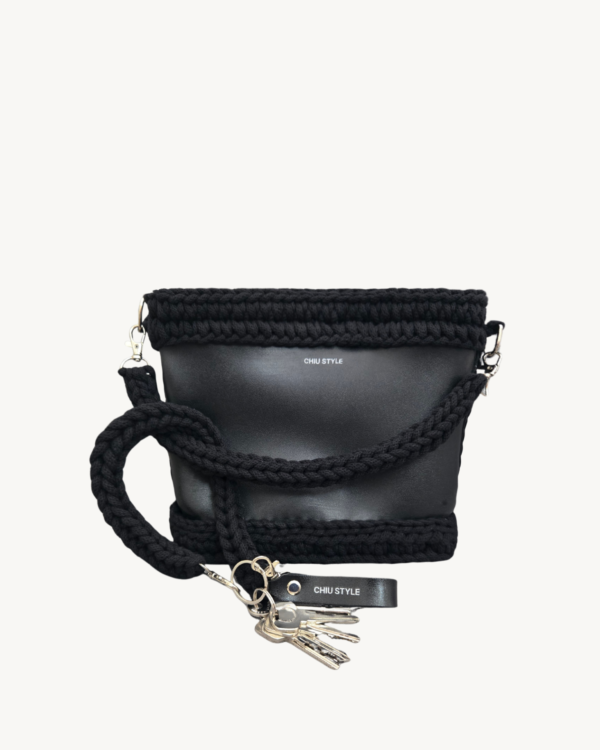 Black vegan leather braided keychain looped around a tote bag handle, demonstrating easy key access inside a handbag