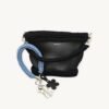 Cornflowers Blue floral vegan leather braided keychain looped around a tote bag handle, demonstrating easy key access inside a handbag