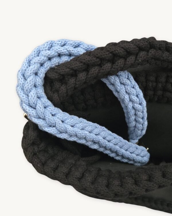Close-up detailed view of the cornflower blue clover vegan leather braided keychain looped around a handbag handle inside a tote