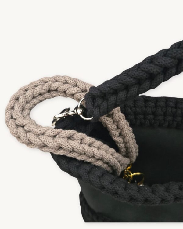 Close-up detailed view of the mocha floral vegan leather braided keychain looped around a handbag handle inside a tote