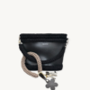 Mocha floral vegan leather braided keychain looped around a tote bag handle, demonstrating easy key access inside a handbag