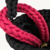 Close-up detailed view of the Sangria floral vegan leather braided keychain looped around a luxury handbag handle inside a tote
