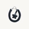 Front view of the CHIU STYLE floral vegan leather braided keychain in Black with Silver Thread, featuring a burnt umber die-cut flower tag and polished silver hardware