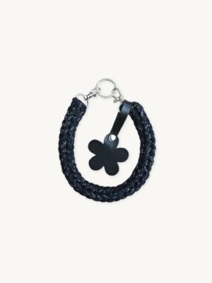 Front view of the CHIU STYLE floral vegan leather braided keychain in Black with Silver Thread, featuring a burnt umber die-cut flower tag and polished silver hardware