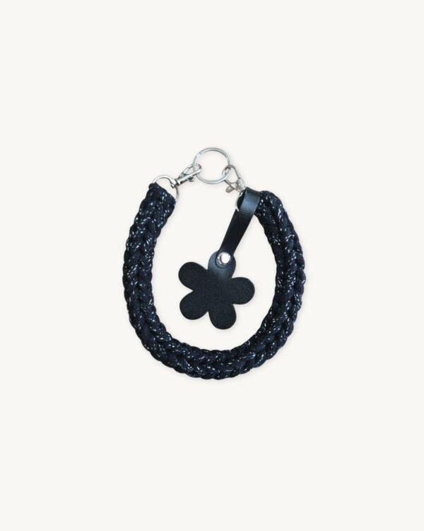 Front view of the CHIU STYLE floral vegan leather braided keychain in Black with Silver Thread, featuring a burnt umber die-cut flower tag and polished silver hardware