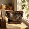 Dark Brown Vintage Punk Vegan Leather Classic Handbag placed on a wooden bench with dappled sunlight streaming through leaves