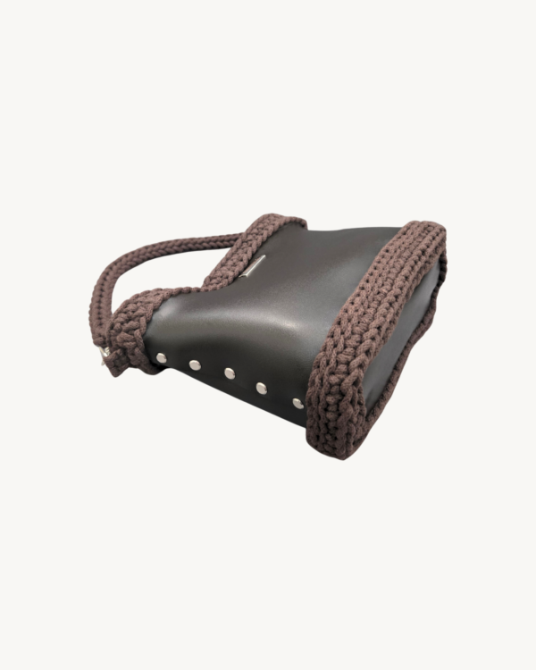 Dark Brown Vintage Punk Vegan Leather Classic Handbag resting sideways on a table showing the structured bottom view